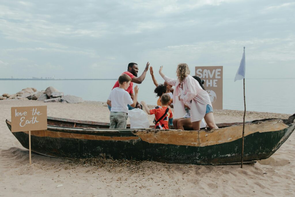 A diverse group of volunteers celebrates teamwork during a beach cleanup.